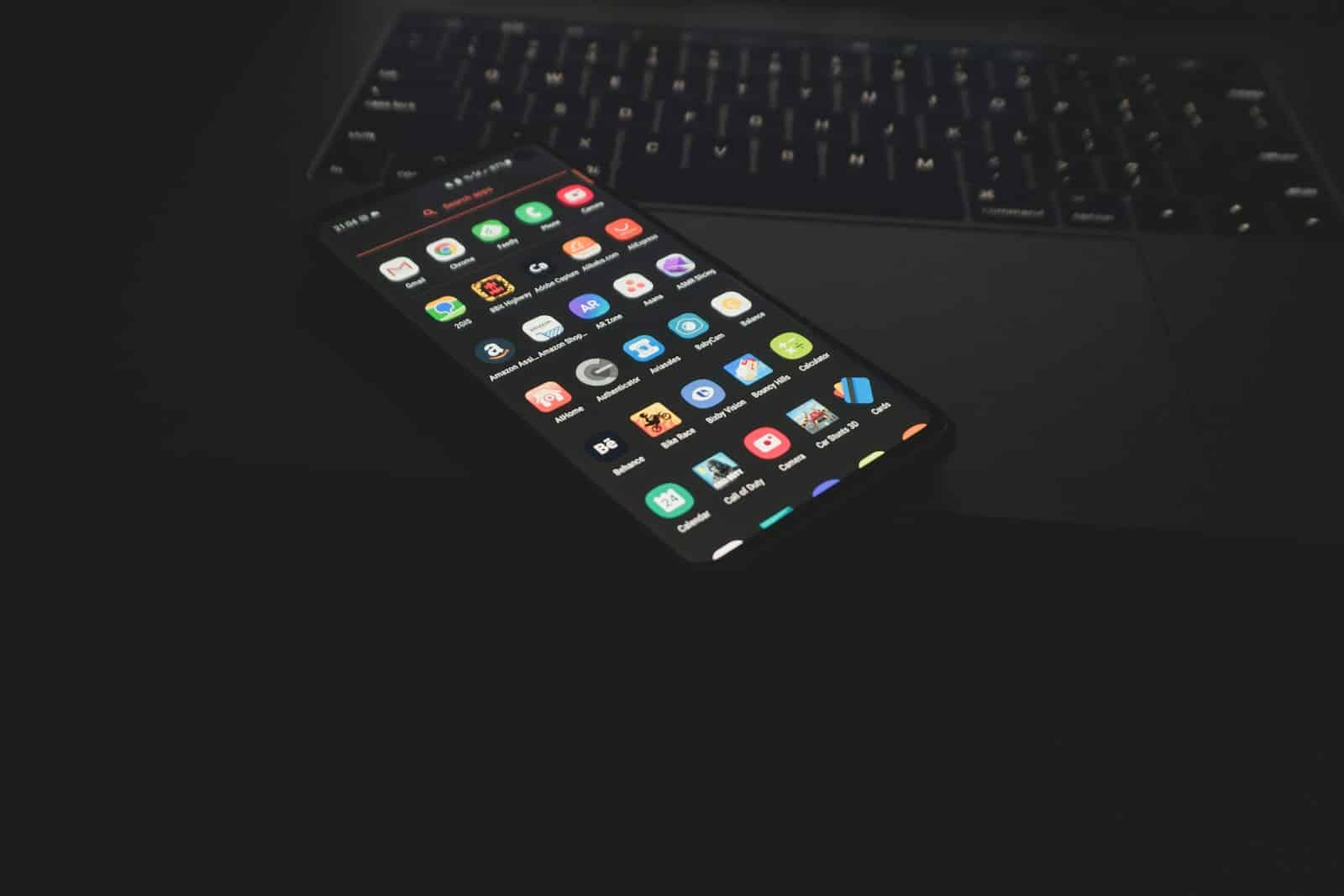 black iphone 5 on black computer keyboard