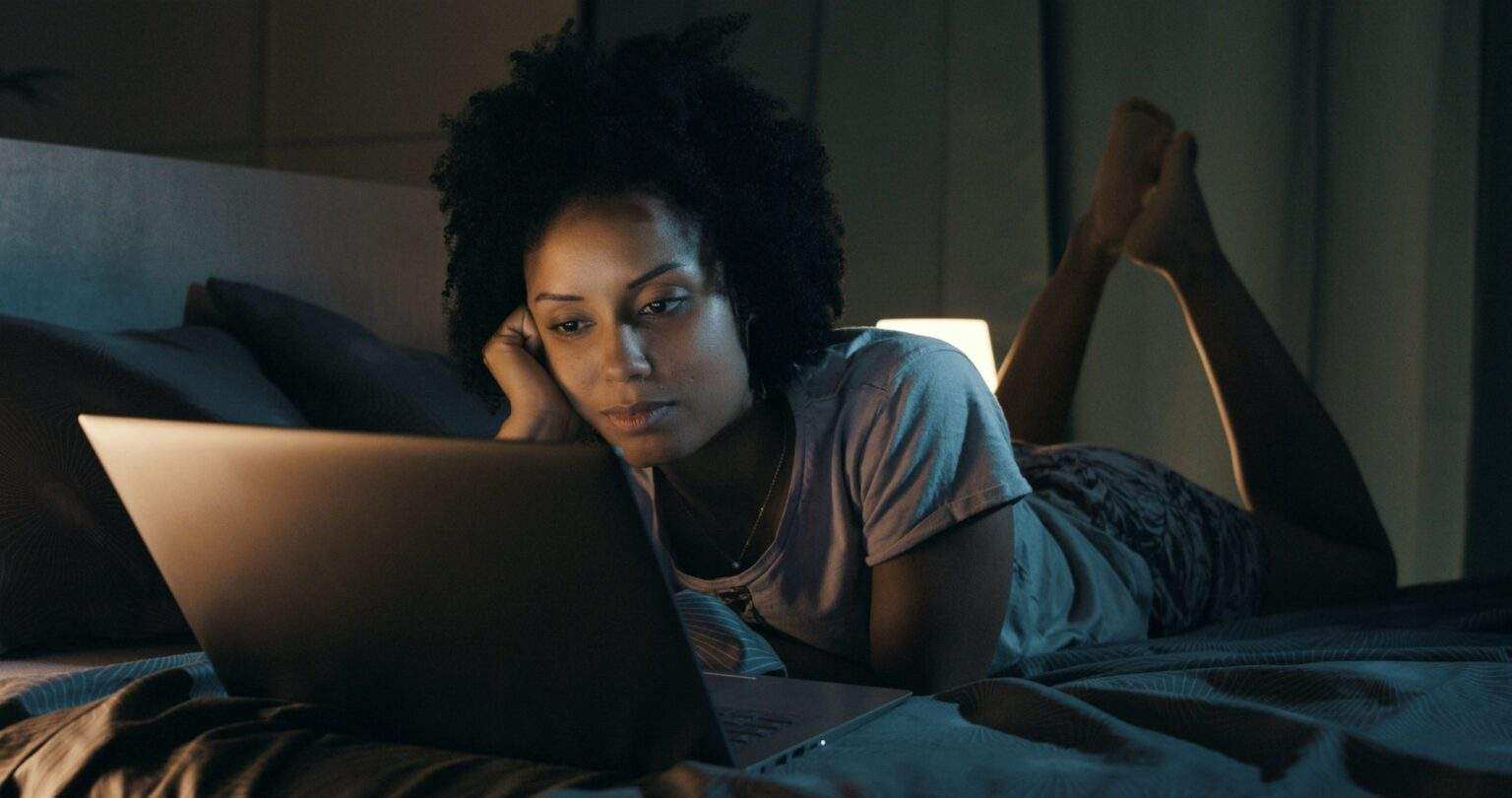 African american woman watching movies at night