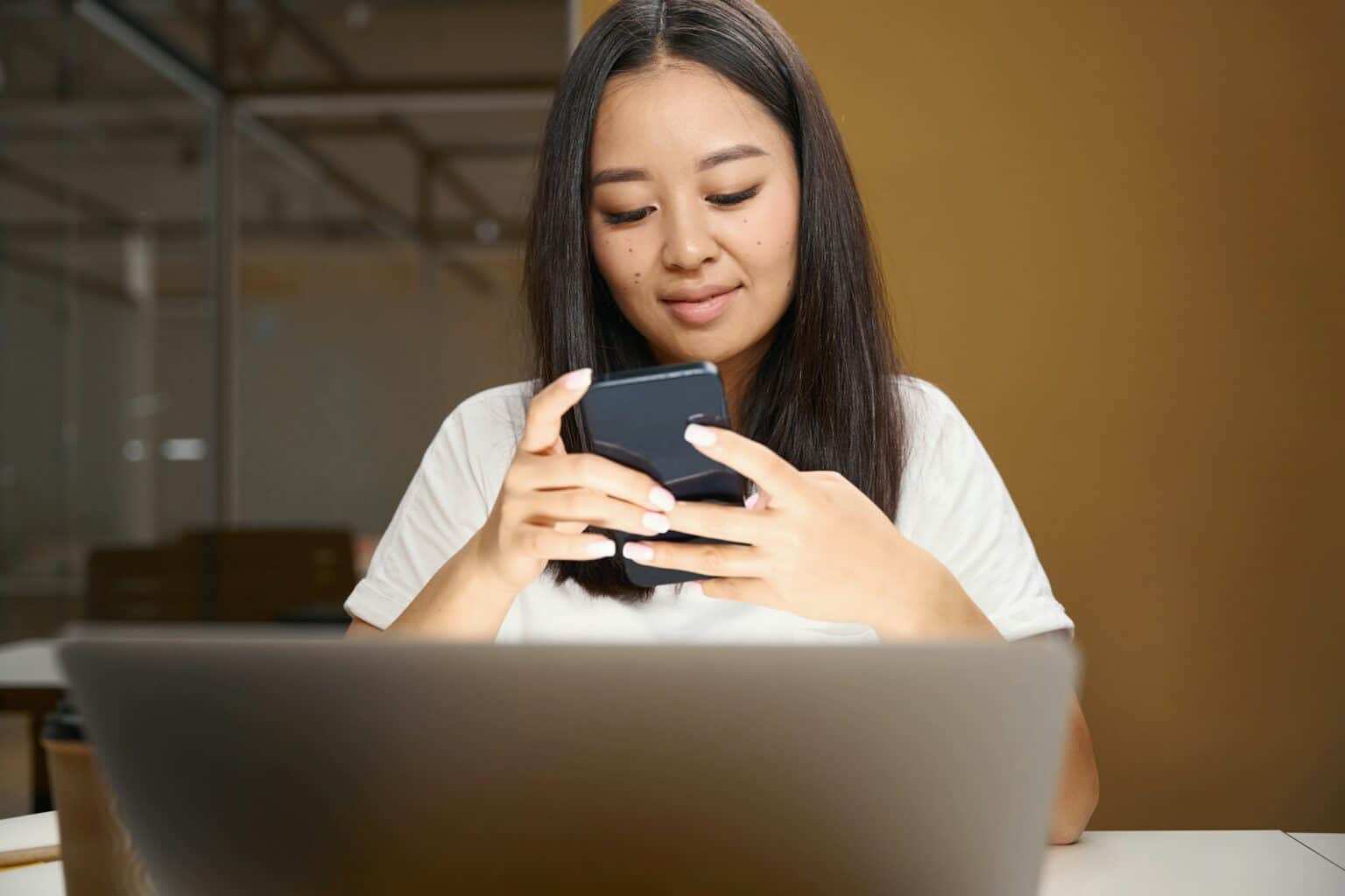 Asian entrepreneur with mobile phone is reading email in conference room
