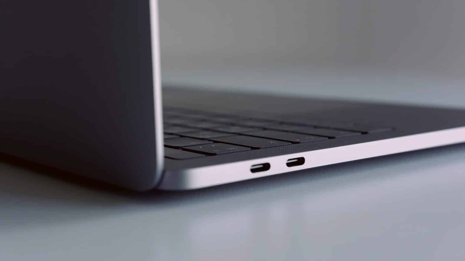 Close up side view of silver laptop on white table. Action. New portable computer details with usb