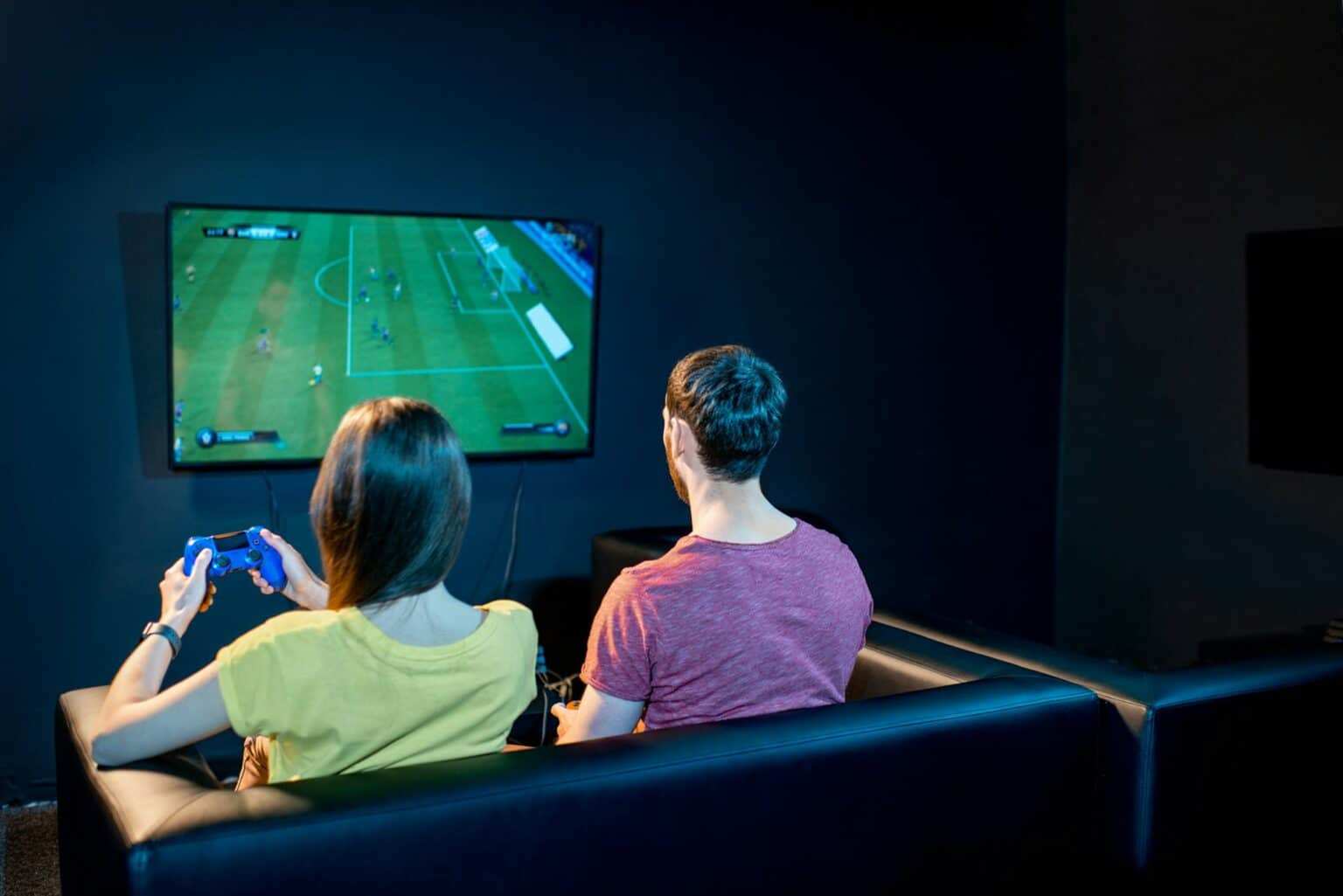 Couple playing football game with gaming console