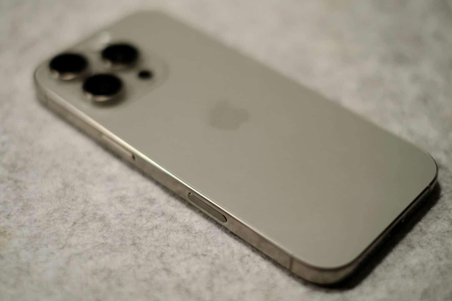A close up of a silver iPhone on a white surface