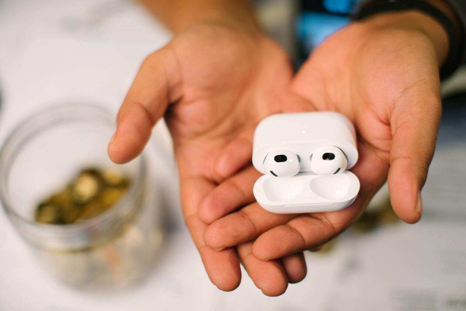 Les Meilleurs Écouteurs True Wireless à Réduction de Bruit Two hands holding the AirPods generation three