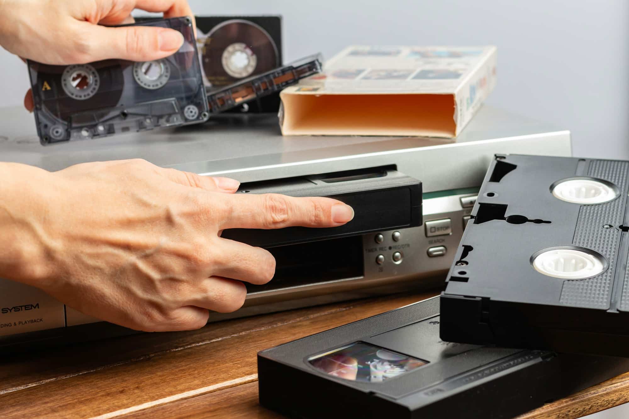 woman's hand inserts cassette into video recorder. Retro and vintage. selective focus