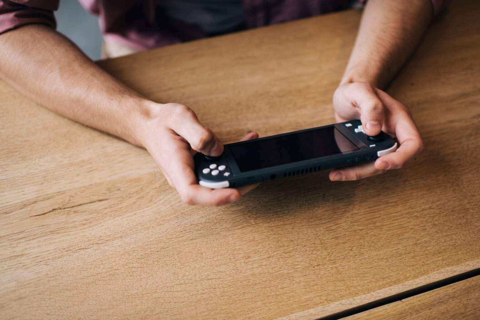 Cropped man holding digital joypad press handheld buttons for win virtual 3s game,