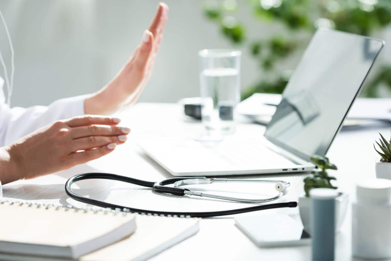 cropped view of doctor having online consultation with patient on laptop in clinic