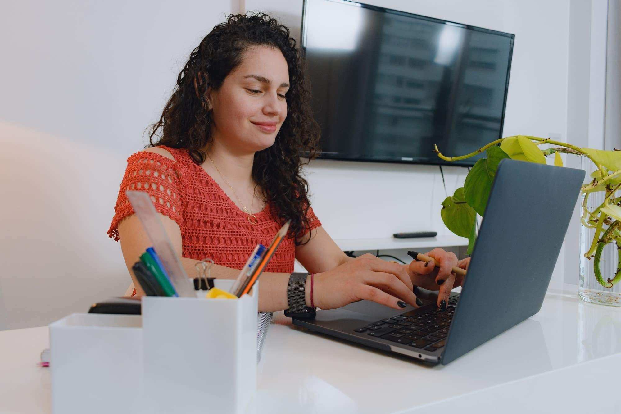 Female editor at home with laptop concentrating on what to write in a script.
