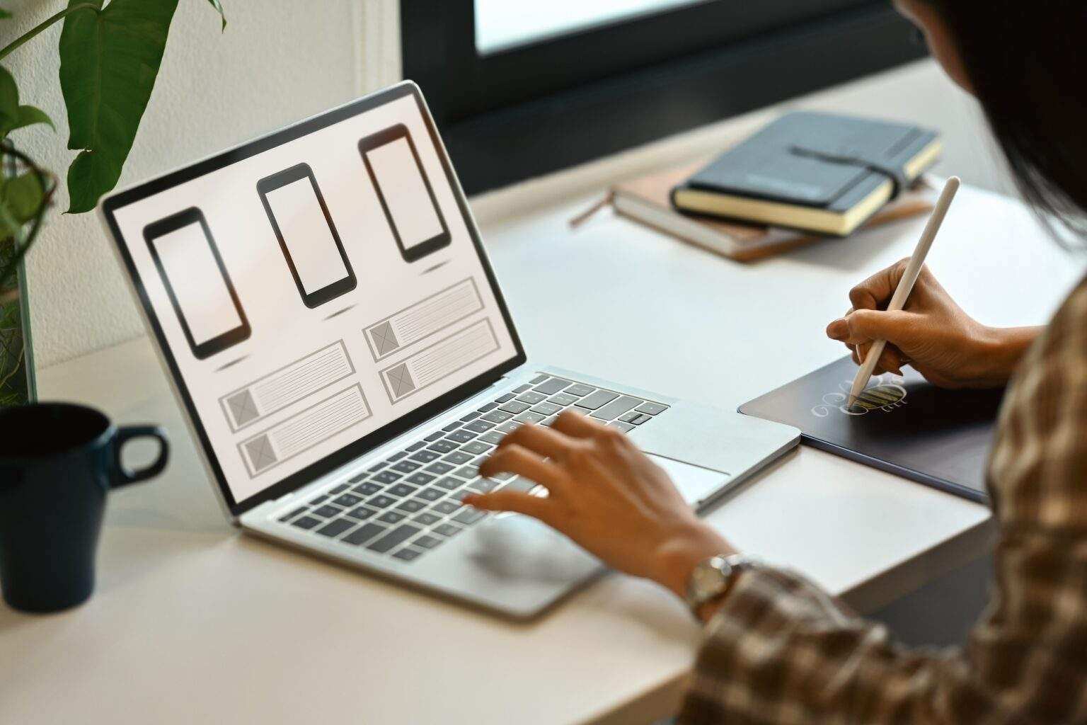 Female website developer planning application development for web mobile phone at workplace.