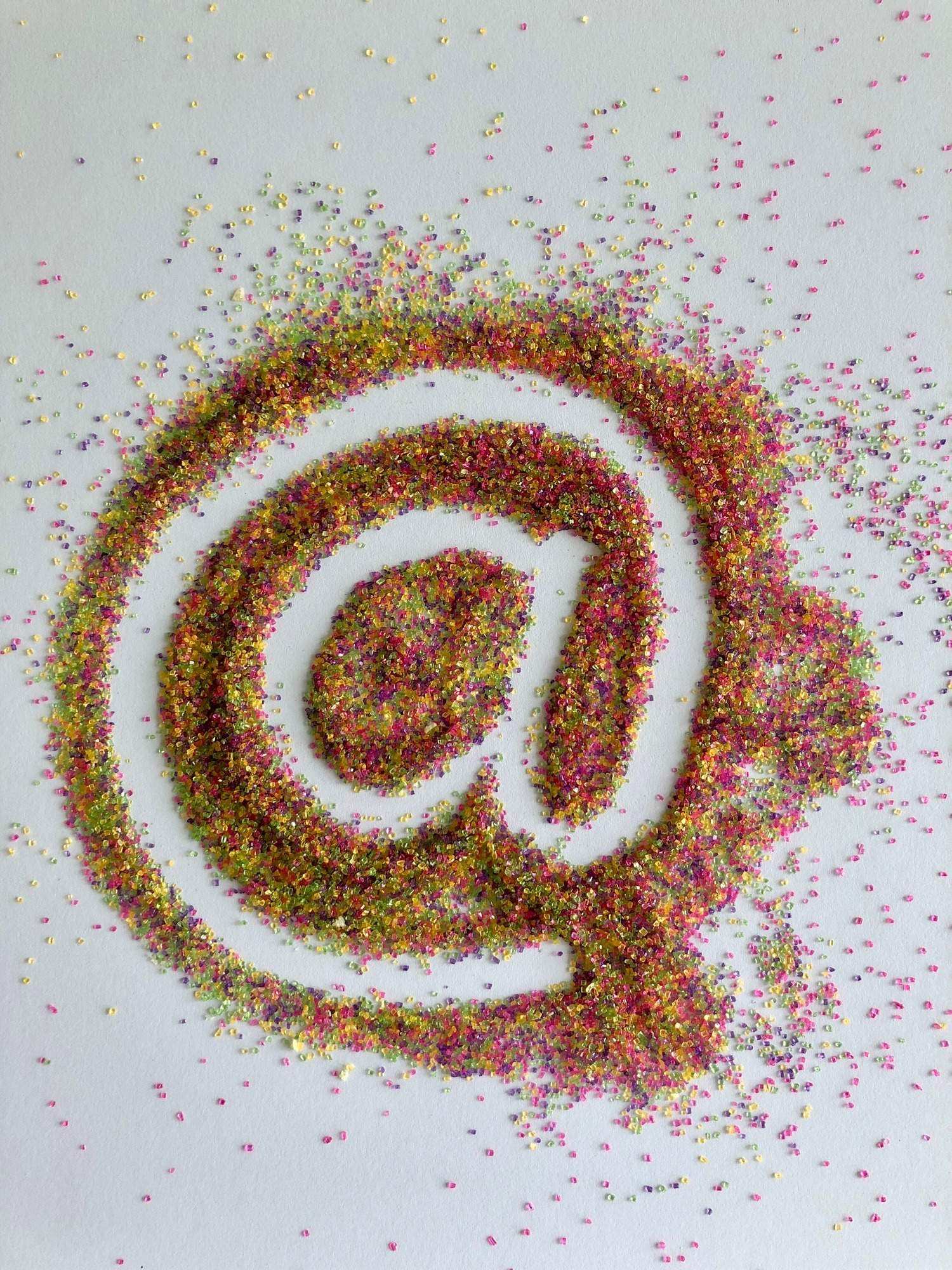 At sign used in social media made with colorful textured sparkly sprinkles