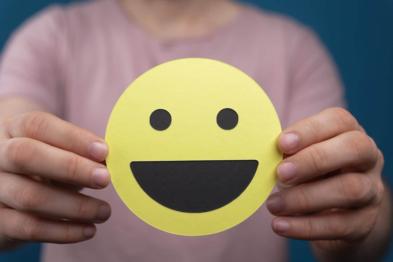 Raccourci clavier pour les emojis : les meilleures méthodes Closeup of the smiley face emoji held by a person