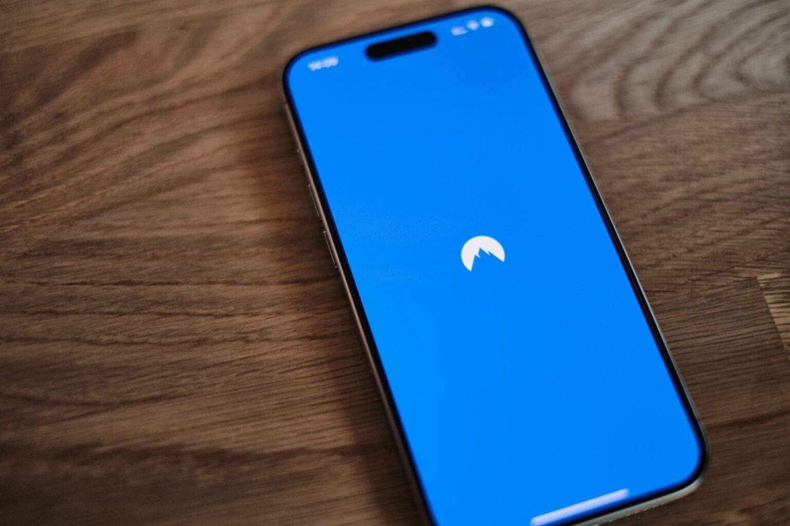 A blue phone sitting on top of a wooden table