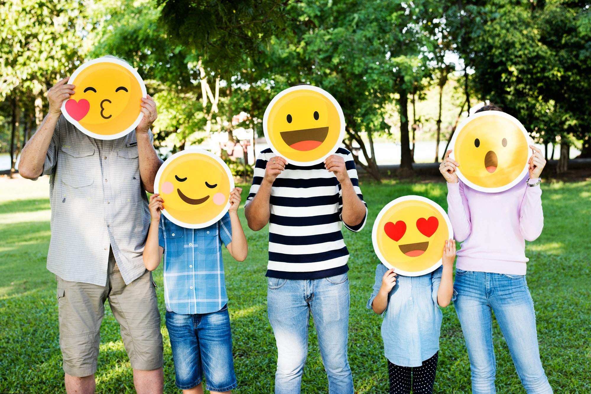 Happy family holding up emojis