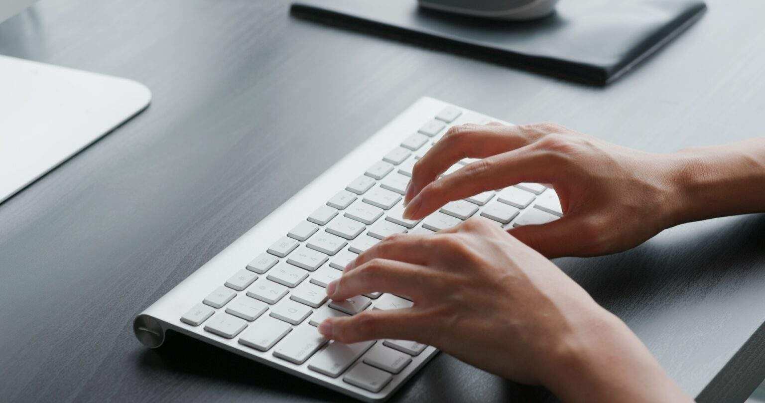 Comment taper les caractères spéciaux sur un clavier d’ordinateur ? Woman type on keyboard at home