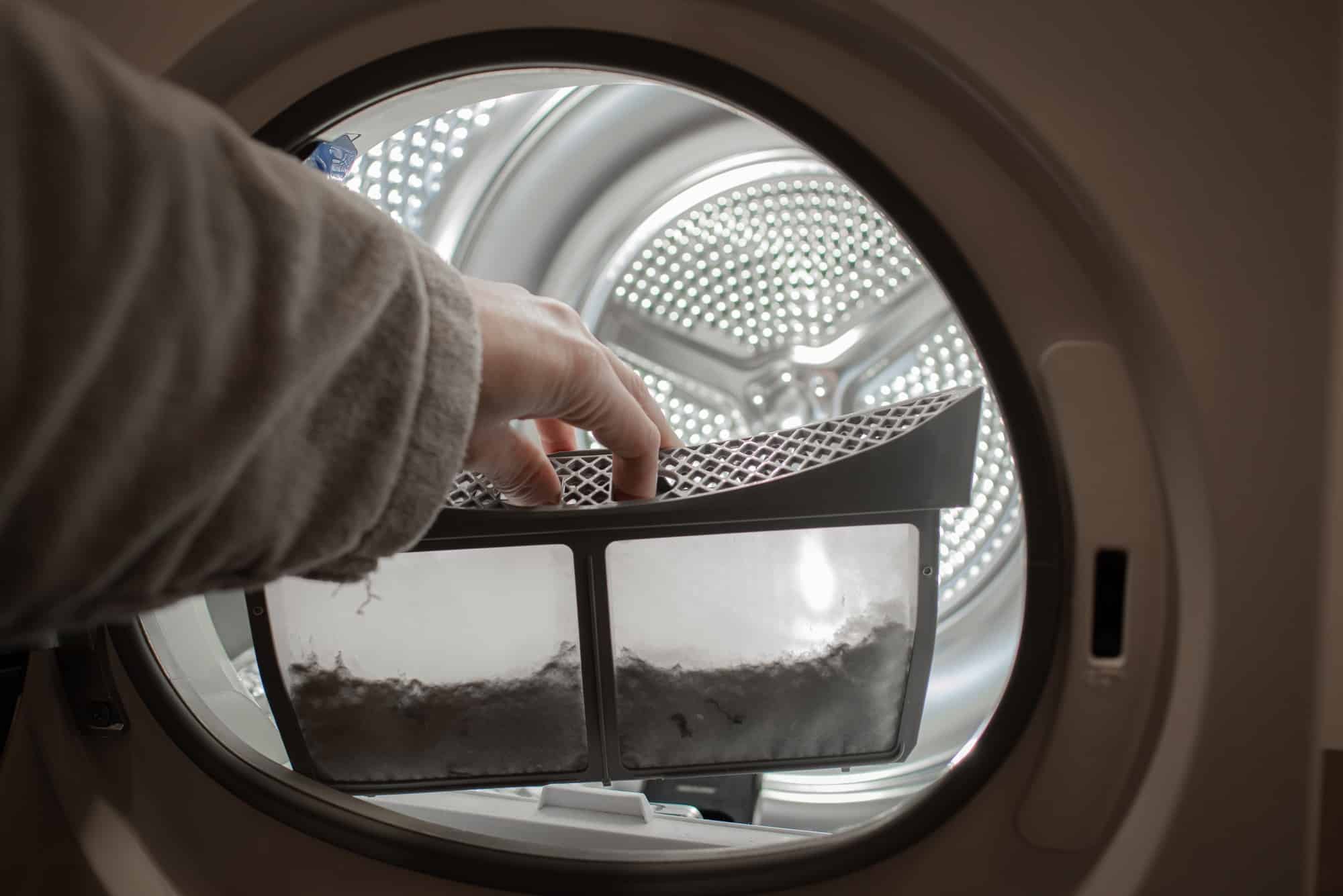 cleanup lints and dirt from tumble dryer filter. Clothes dryer lint filter that is covered with lint