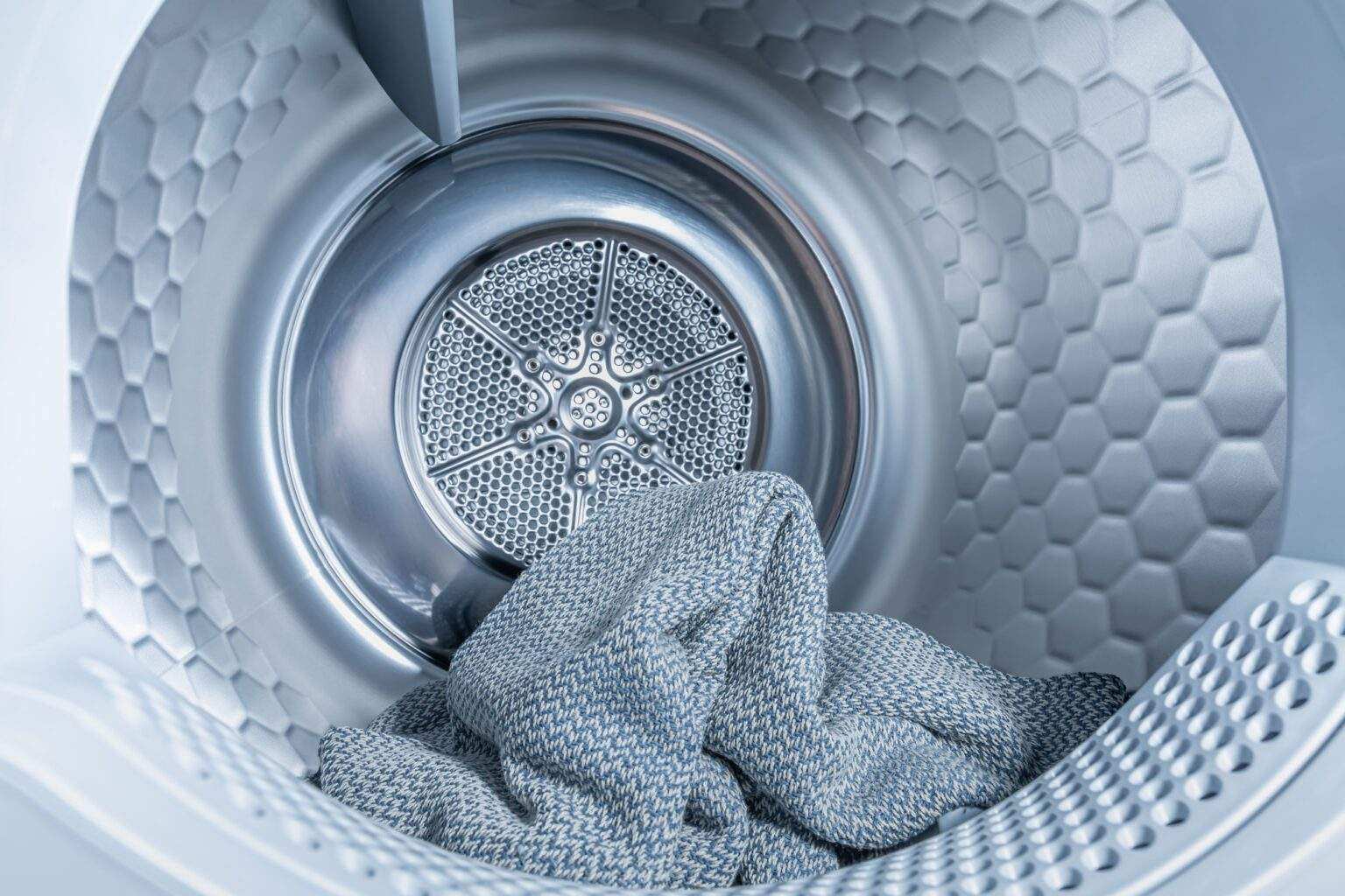 Votre guide ultime pour choisir le sèche-linge parfait Inside of tumble dryer with clean laundry - new generation of heat pump dryer, household concept