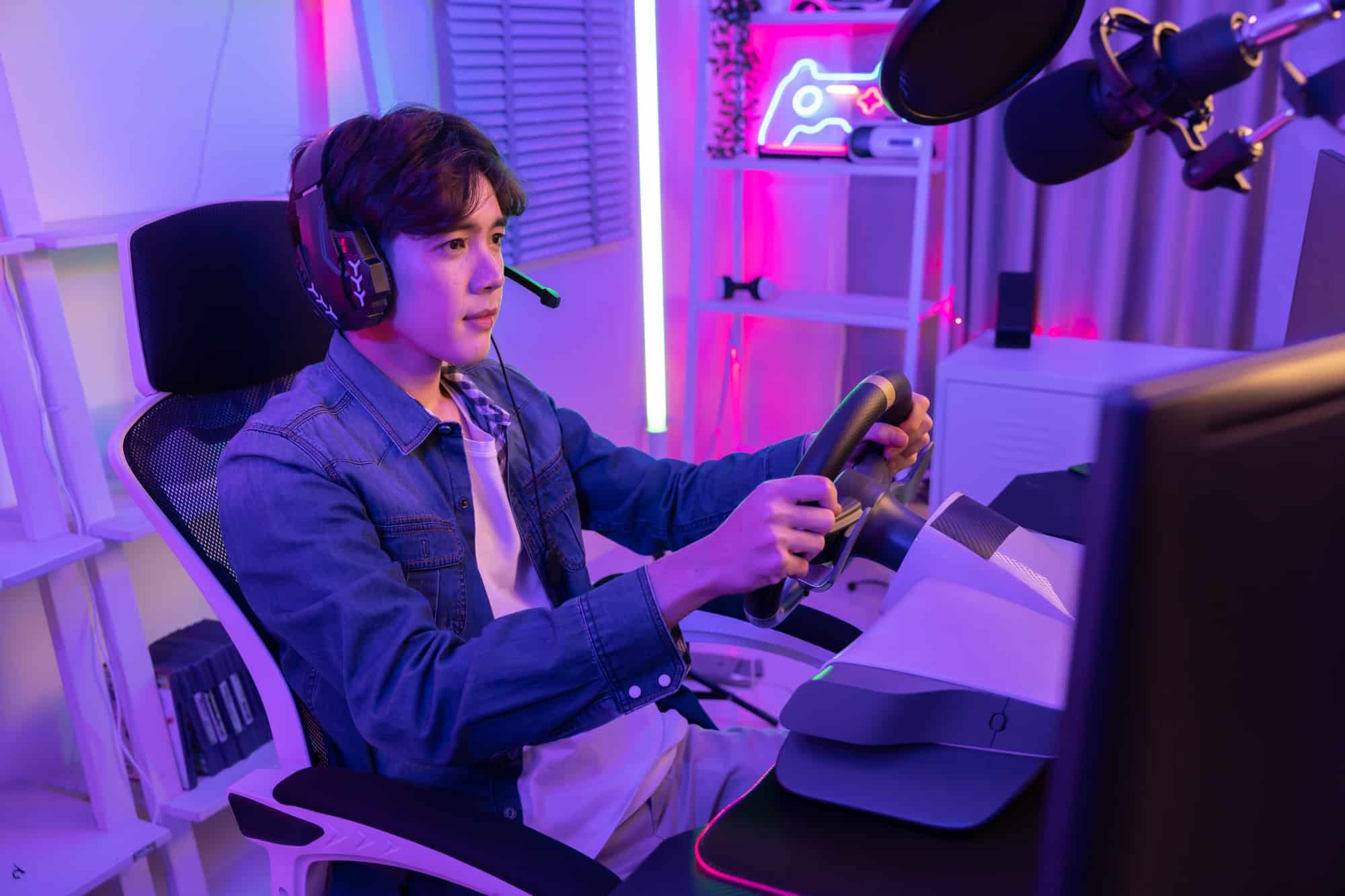 Male Esport Gamer with Car Steering Wheel Joy Controller playing driving simulator Online Video Game