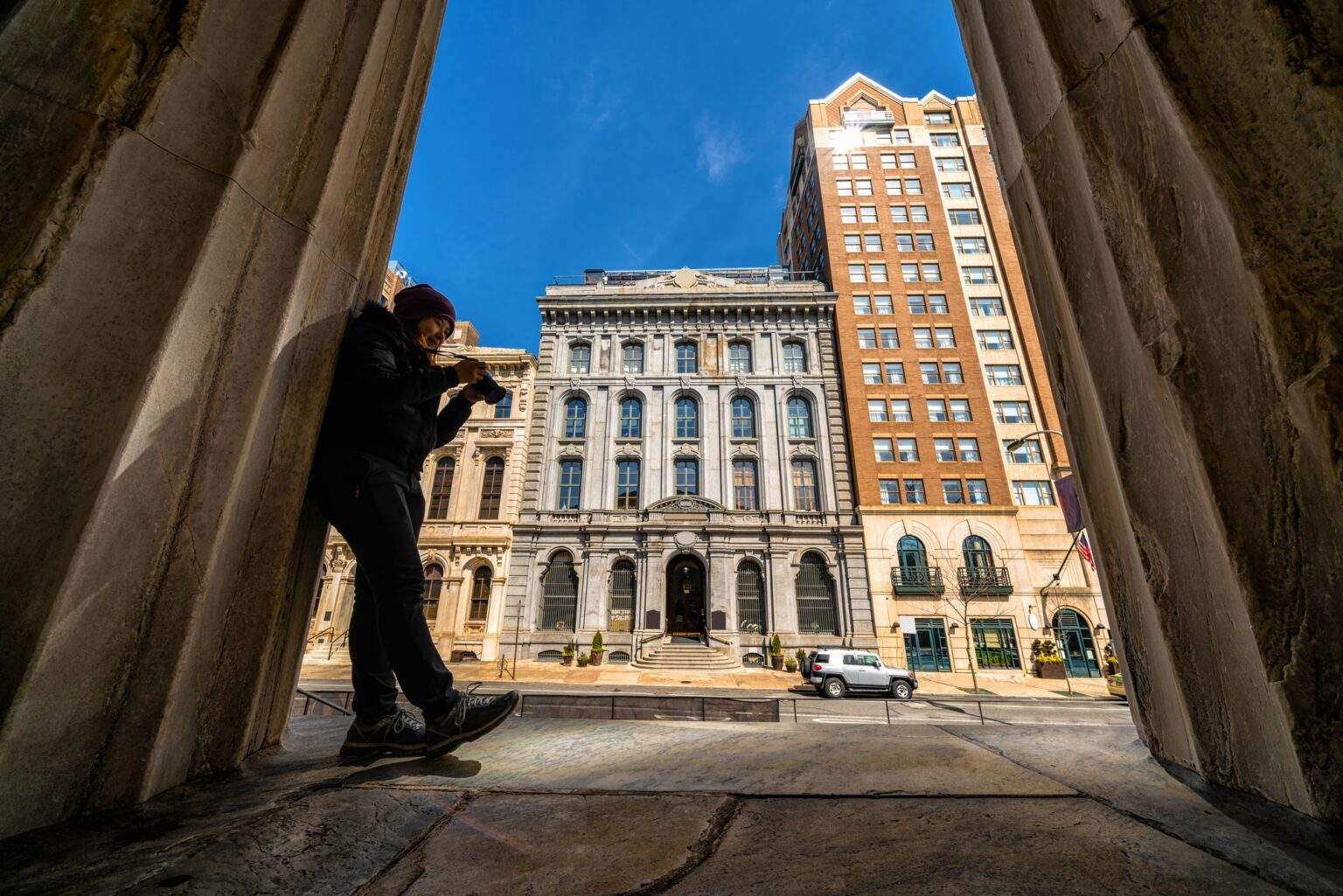 Asian young woman checking and using the camera over the bank of philadelphia,