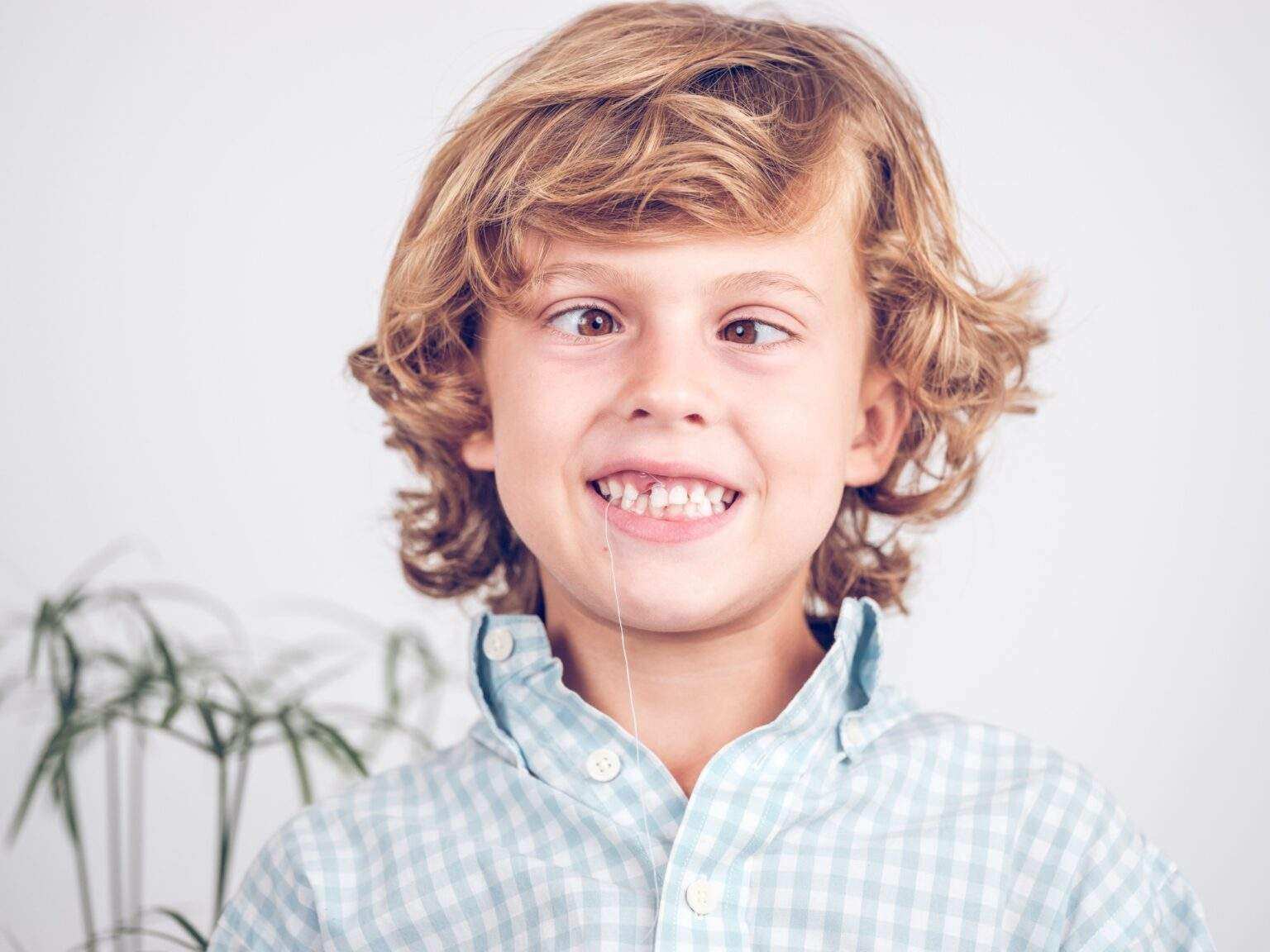 Cheerful preteen boy with twitched out tooth grimacing