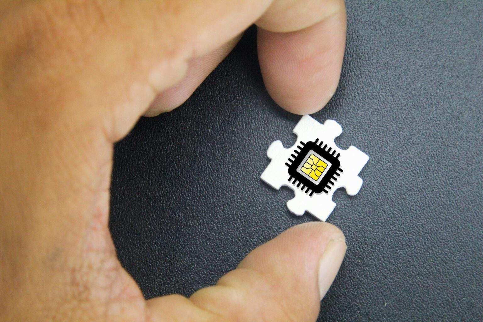 hand holding puzzle with microchip icon.